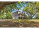 Stately home with a grand facade, featuring a sprawling porch and lush surroundings at 5569 Frisco Ln, Johns Island, SC 29455