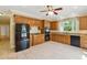 Well-equipped kitchen with granite countertops, tile floors, wood cabinetry, and black appliances at 5569 Frisco Ln, Johns Island, SC 29455