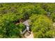 An aerial view shows the home nestled among lush trees, a two-car garage, and a spacious driveway with a golf cart at 595 Crowned Kinglet Retreat, Charleston, SC 29412