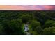 An aerial twilight view captures the home nestled among lush trees, creating a sense of privacy and tranquility at 595 Crowned Kinglet Retreat, Charleston, SC 29412