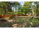 Expansive backyard featuring a lush lawn, mature trees, and a wooden fence at 595 Crowned Kinglet Retreat, Charleston, SC 29412