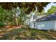 Spacious backyard featuring a wooden deck, lush green grass, and mature trees for shade at 595 Crowned Kinglet Retreat, Charleston, SC 29412