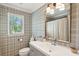 Well-decorated bathroom with plaid wallpaper, white vanity, and a framed mirror at 595 Crowned Kinglet Retreat, Charleston, SC 29412