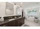 Bathroom featuring double sinks, a shower, and a soaking tub near the walk-in closet at 595 Crowned Kinglet Retreat, Charleston, SC 29412