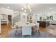 Light-filled dining area with a round table, upholstered chairs, and views into the modern kitchen at 595 Crowned Kinglet Retreat, Charleston, SC 29412