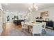 Open-concept dining room boasts a stylish chandelier and connects to a modern kitchen with an island at 595 Crowned Kinglet Retreat, Charleston, SC 29412
