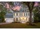 Charming two-story home with a two-car garage and meticulously landscaped front yard, bathed in the soft glow of twilight at 595 Crowned Kinglet Retreat, Charleston, SC 29412