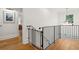 Bright landing with iron railing overlooking wood stairs and hardwood floors at 595 Crowned Kinglet Retreat, Charleston, SC 29412