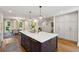 Kitchen island with seating and storage has quartz countertops with a view of the dining area and entryway at 595 Crowned Kinglet Retreat, Charleston, SC 29412