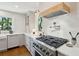 This kitchen features a professional range, custom hood, and bright white tile backsplash at 595 Crowned Kinglet Retreat, Charleston, SC 29412