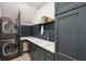 Laundry room featuring a stacked washer and dryer, with navy blue cabinets and a sink at 595 Crowned Kinglet Retreat, Charleston, SC 29412