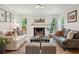 Inviting living room with fireplace, hardwood floors, and natural light from surrounding windows at 595 Crowned Kinglet Retreat, Charleston, SC 29412