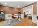 A bright office with hardwood floors features a modern desk, stylish chair, and access to the living room at 595 Crowned Kinglet Retreat, Charleston, SC 29412