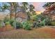 Beautiful landscaped backyard featuring a view of the brick house and mature trees at 7 Andrea Ct, Hanahan, SC 29410