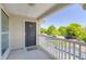 Private covered balcony featuring an entrance door and white railings overlooking lush green trees at 700 Daniel Ellis Dr # 10307, Charleston, SC 29412