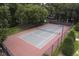 Aerial view of a well-maintained tennis court with green and red surface surrounded by tall trees at 700 Daniel Ellis Dr # 10307, Charleston, SC 29412