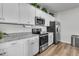 Modern kitchen featuring white cabinets, stainless steel appliances, and granite countertops, providing a stylish cooking space at 707 Butter Rd, Bonneau, SC 29431