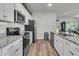 Bright kitchen with white cabinets, granite countertops, and wood-look floors, offering both style and functionality at 707 Butter Rd, Bonneau, SC 29431