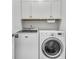 Well-organized laundry room featuring a modern washer and dryer beneath clean white cabinets at 707 Butter Rd, Bonneau, SC 29431