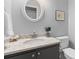 Well lit half bathroom with gray vanity, granite countertop, and decorative mirror at 715 Majestic Oak Dr, Charleston, SC 29412