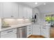 Bright kitchen features white cabinets, stainless steel appliances, and hardwood floors at 715 Majestic Oak Dr, Charleston, SC 29412