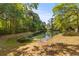 Scenic view of a peaceful pond surrounded by lush trees and greenery at 715 Majestic Oak Dr, Charleston, SC 29412