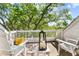 Charming balcony featuring white chairs, a small table, and a view of the surrounding greenery at 732 Spinnaker Beachhouse, Seabrook Island, SC 29455