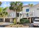 Beautifully landscaped grounds and mature palms frame this raised beach home with updated siding and driveway at 732 Spinnaker Beachhouse, Seabrook Island, SC 29455