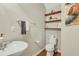 A half bathroom features a pedestal sink, toilet, decorative shelves, and light-colored walls at 853 Bibury Ct, Charleston, SC 29414