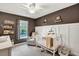 Charming Bedroom with a white crib, glider, ceiling fan, and decorative wall shelves at 853 Bibury Ct, Charleston, SC 29414