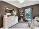 A Bedroom features a dresser with a changing table, a window, and a chair with a floral pillow at 853 Bibury Ct, Charleston, SC 29414