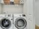 This laundry room features modern, front-loading washing machine and dryer with wire shelving above at 853 Bibury Ct, Charleston, SC 29414