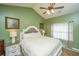 Bright bedroom featuring a comfortable bed with green walls and natural light, with a ceiling fan at 8652 Grassy Oak Trl, North Charleston, SC 29420