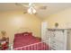 Bedroom features ceiling fan, barn door style dresser, and red bedspread at 8652 Grassy Oak Trl, North Charleston, SC 29420