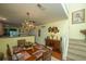 A bright dining room has a wooden table with a chandelier, with view of the staircase at 8652 Grassy Oak Trl, North Charleston, SC 29420