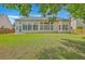 This backyard features a well maintained lawn and an outdoor view of the sunroom addition at 9379 Harroway Rd, Summerville, SC 29485