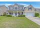 Inviting two-story home with a classic facade, complemented by lush green lawn at 9379 Harroway Rd, Summerville, SC 29485