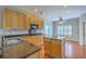 Well-lit kitchen boasts granite countertops, island, stainless steel sink, and ample cabinet space at 9379 Harroway Rd, Summerville, SC 29485