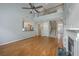 Bright living room with hardwood floors, fireplace, open staircase, and open view into kitchen at 9379 Harroway Rd, Summerville, SC 29485