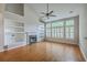 Bright living room boasts hardwood floors, fireplace, ceiling fan and built-in shelving at 9379 Harroway Rd, Summerville, SC 29485