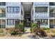 Exterior view of gated entry to condo building with manicured landscaping and colorful roses at 1025 Riverland Woods Pl # 1008, Charleston, SC 29412