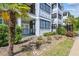 Well-maintained condo building featuring balconies and a lush, landscaped yard with palm trees at 1025 Riverland Woods Pl # 1008, Charleston, SC 29412