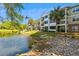 Exterior view of condo buildings overlooking a pond with rock lined banks at 1025 Riverland Woods Pl # 1008, Charleston, SC 29412