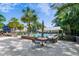 Outdoor pool area with comfortable seating, manicured landscaping, and a clubhouse in the background at 1025 Riverland Woods Pl # 1008, Charleston, SC 29412