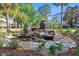 Beautiful stone water feature with lush green landscaping and palm trees in the background at 1025 Riverland Woods Pl # 1008, Charleston, SC 29412