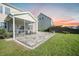 Landscaped backyard featuring a stone patio, screened-in porch, lush lawn, and private setting at 103 Radtko Rd, Summerville, SC 29486