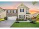 Charming two-story home boasts a mix of brick and siding, well-manicured lawn and attached two-car garage at 103 Radtko Rd, Summerville, SC 29486