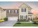 Home featuring manicured lawn, garden beds, brick and siding facade, and concrete driveway leading to attached garage at 103 Radtko Rd, Summerville, SC 29486