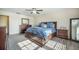 Sunlit bedroom features a large bed with blue bedding, side tables, and a full-length mirror at 103 Radtko Rd, Summerville, SC 29486