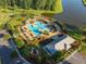 Aerial view showcases the large community pool and recreation area near a lake, surrounded by lush trees at 103 Radtko Rd, Summerville, SC 29486
